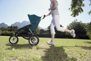 Woman Running with Baby Carriage in Park