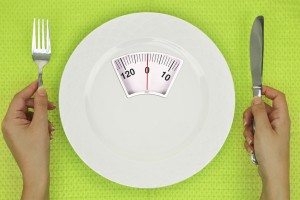 Hands and plate with weighing scale on the table