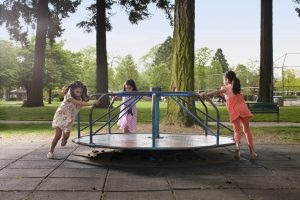 kids on carousal in playground