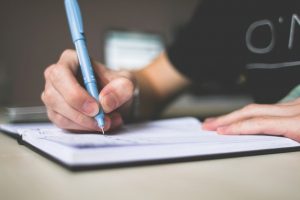 Person Writting Down Routine 12 Super Effective Evening Routine Ideas for More Energy and Focus