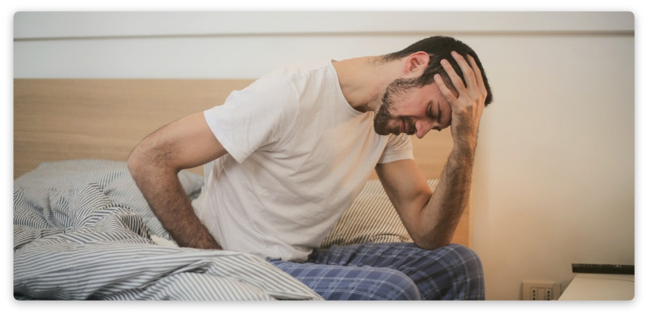 young-man-in-sleepwear-suffering-from-headache-in-morning-3771115